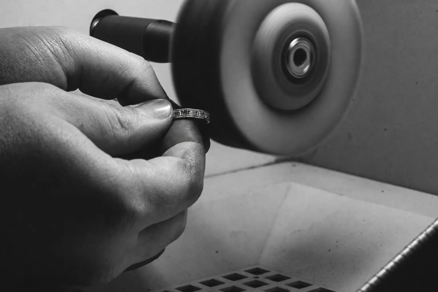 Polishing a set ring with a polishing wheel.