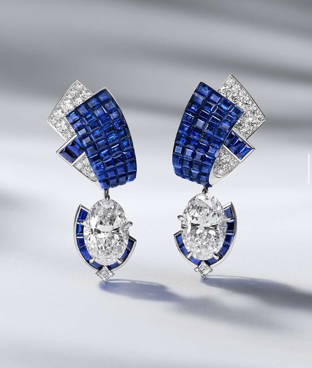 Sapphire earrings, an unbroken blue surface beside brilliant cut diamonds.