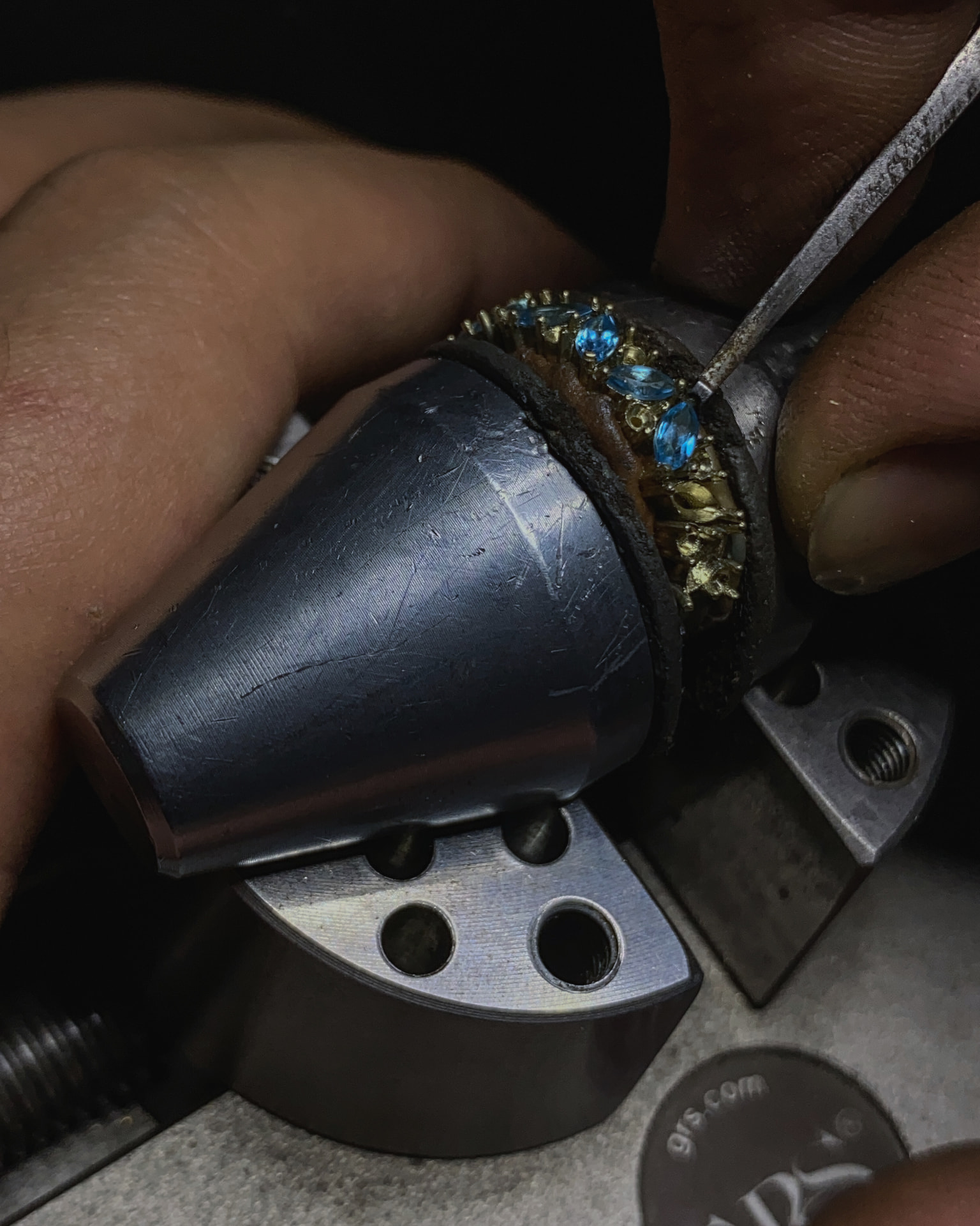 Setting marquise cut blue topaz, one stone at a time, on the bench pin.