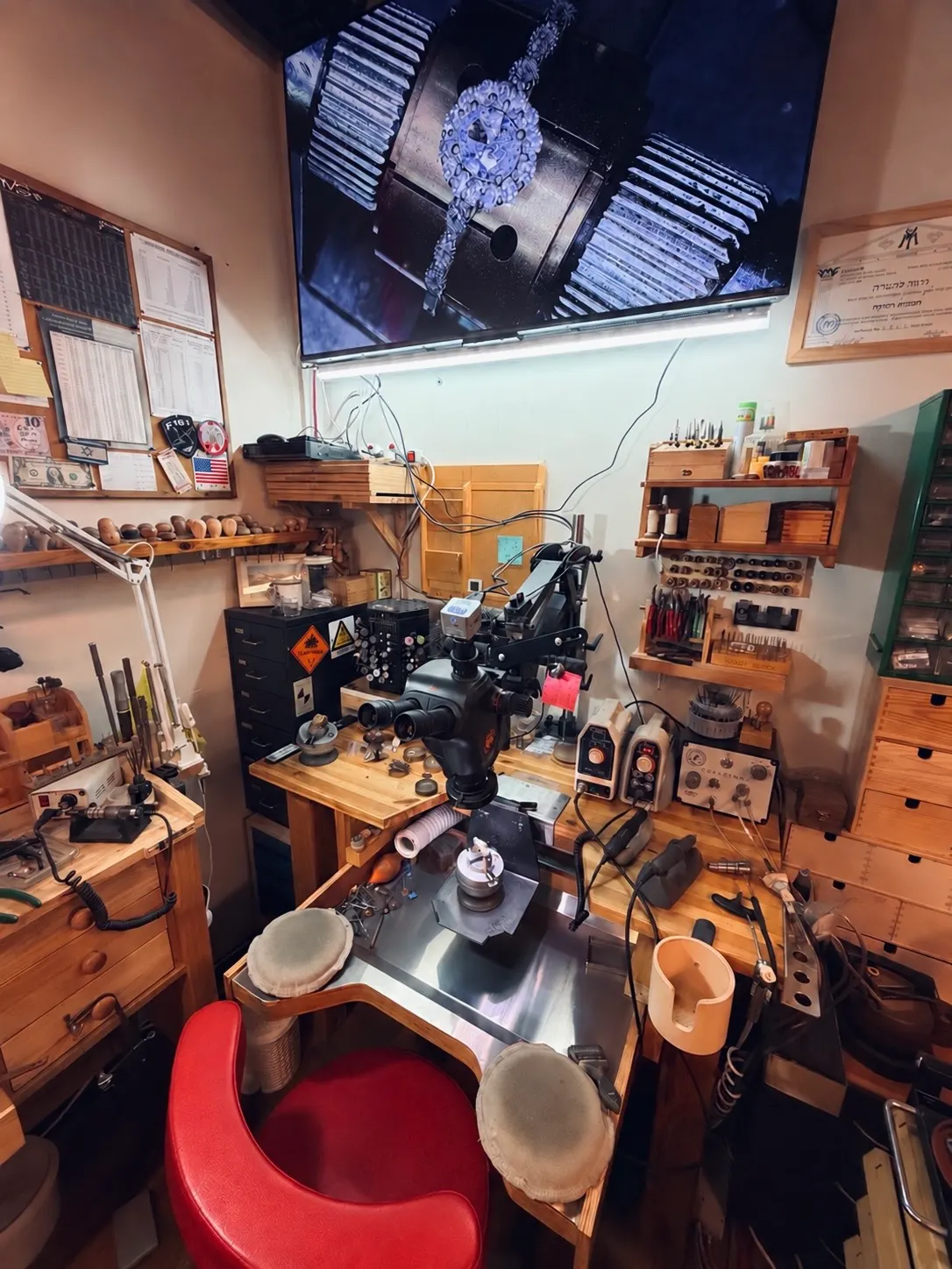 The stone setter's bench: microscope, engraving knives and tools, with the work magnified on the screen above.