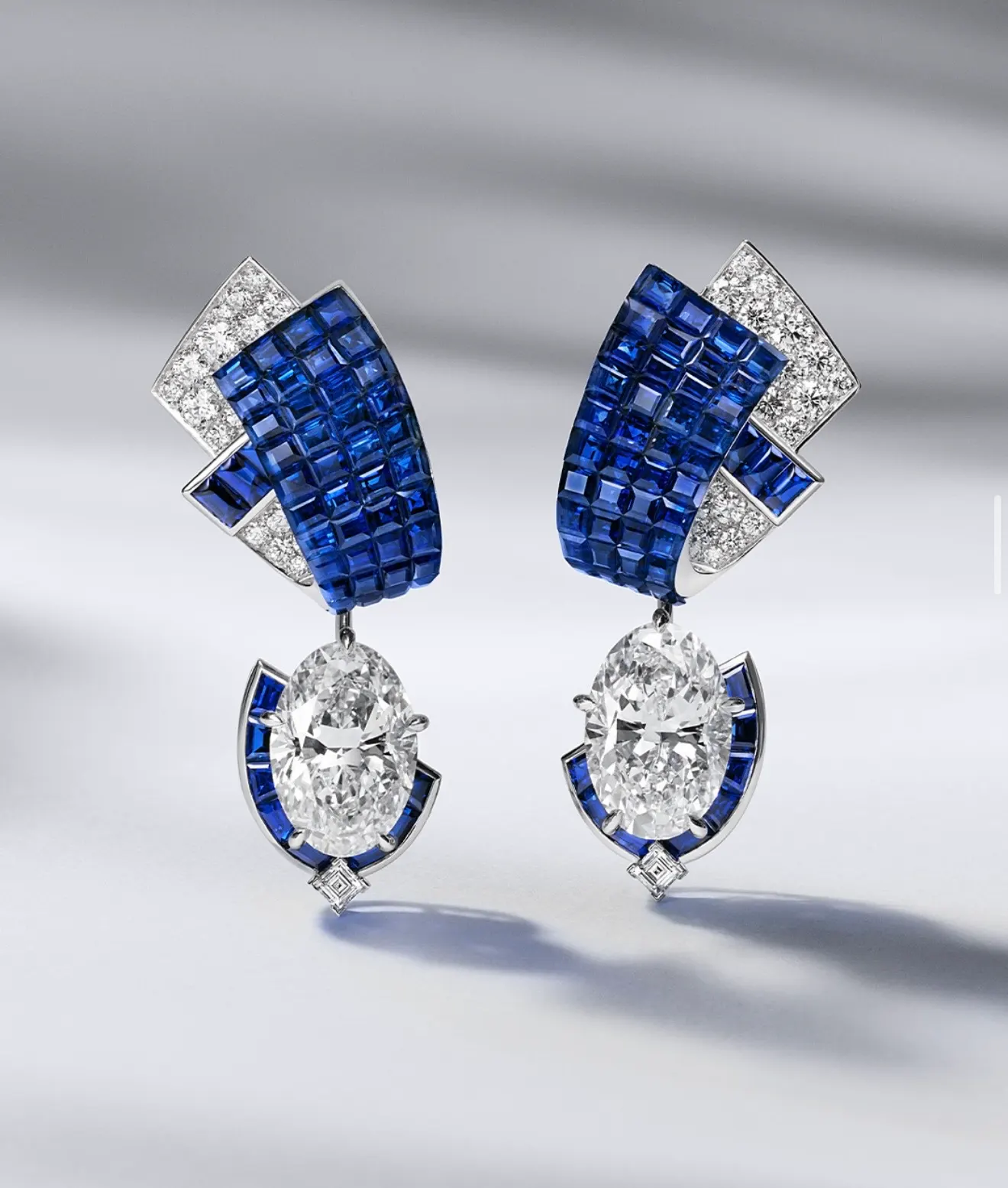 Sapphire earrings, an unbroken blue surface beside brilliant cut diamonds.
