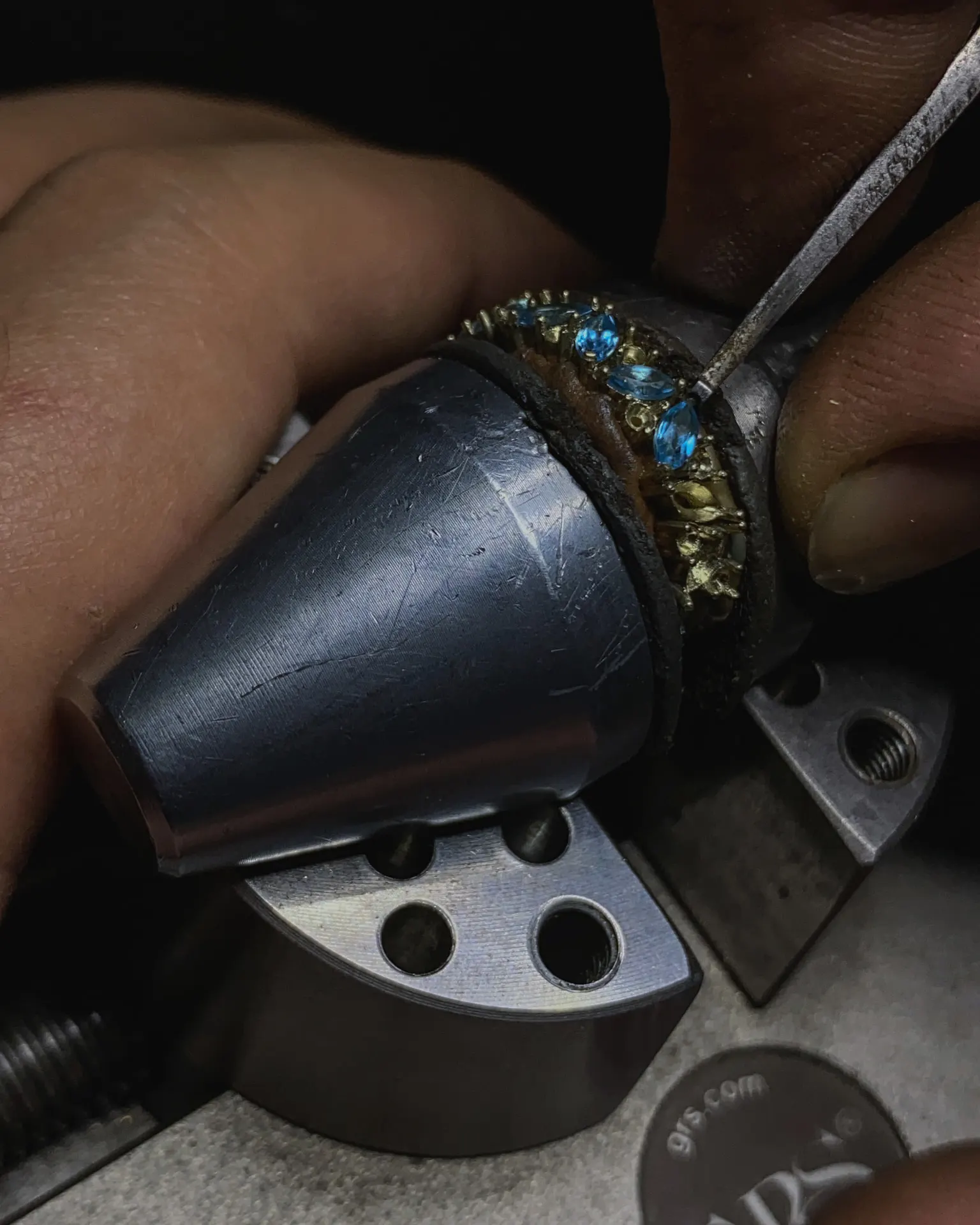 Setting marquise cut blue topaz, one stone at a time, on the bench pin.