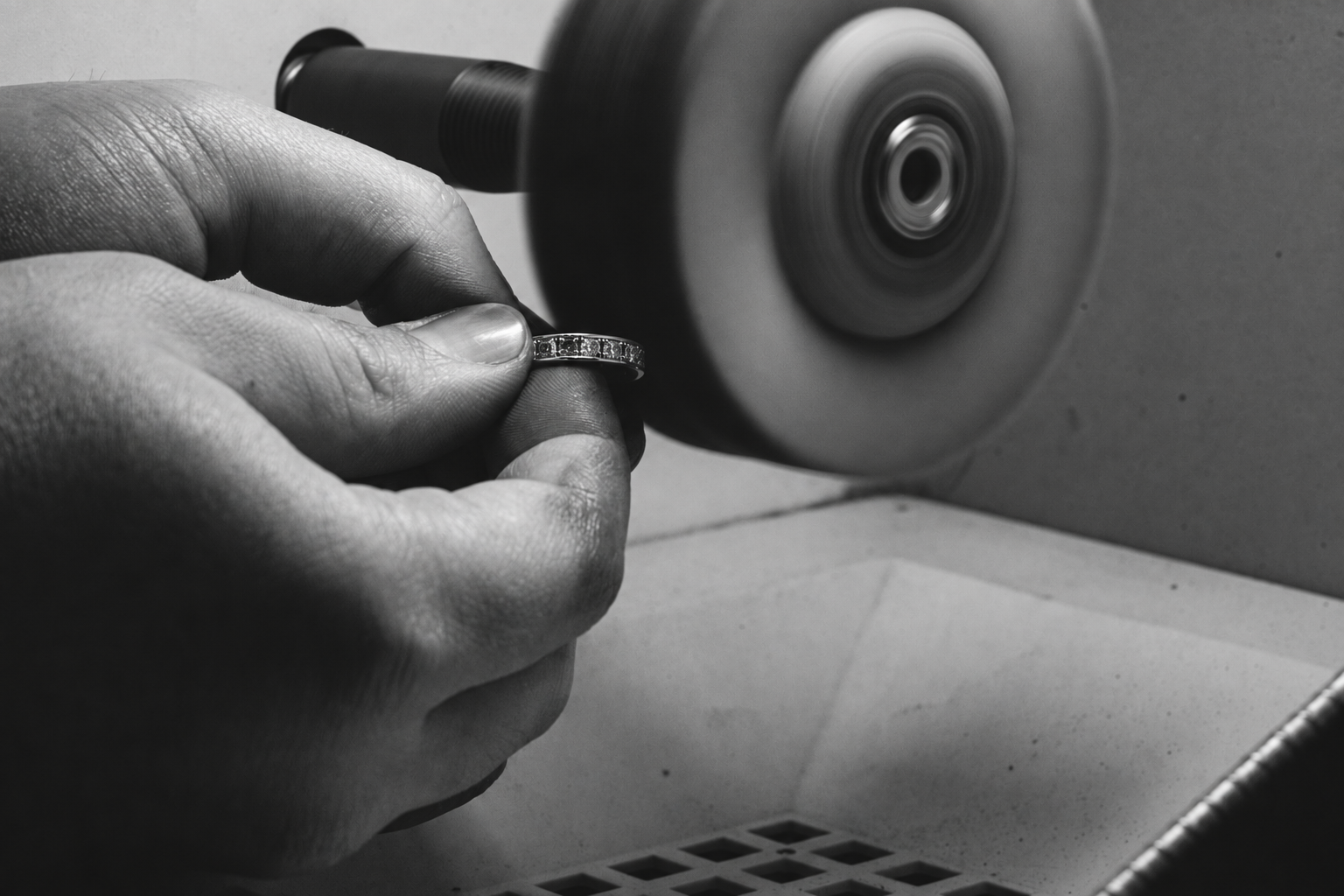 Polishing a set ring with a polishing wheel.