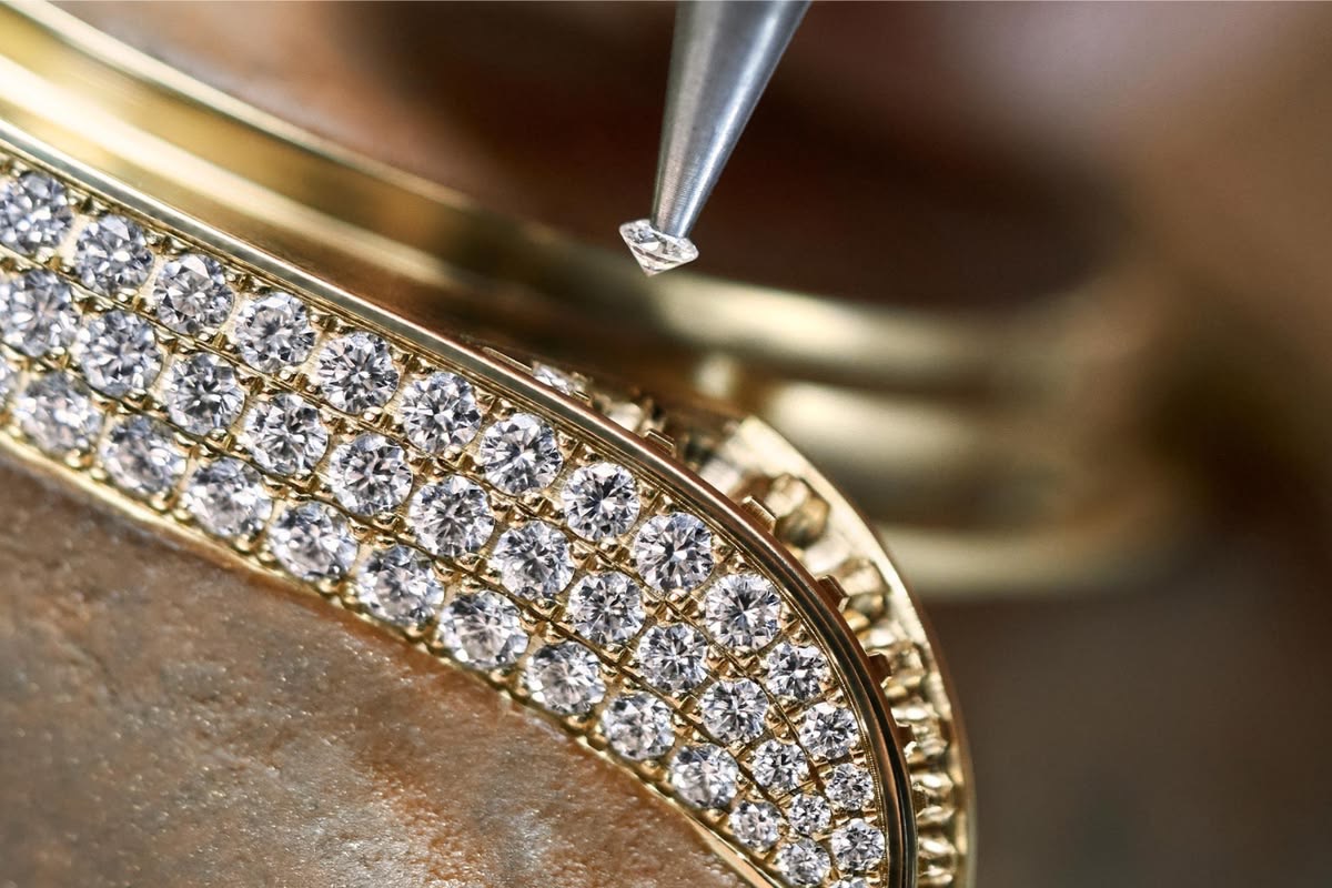 Rows of pavé diamonds under magnification, one stone still waiting.